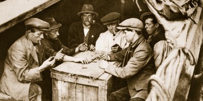 A bargee and friends playing dominoes in the hold of a barge, London by English Photographer